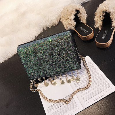 Κομψή γυαλιστερή γυναικεία τσάντα με μεταλλική λαβή και μεταλλικά διακοσμητικά