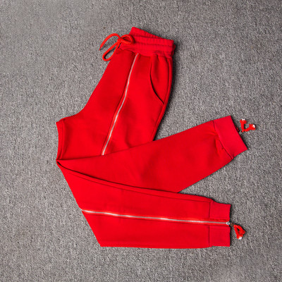 Fashionable women`s sports pants with high waist and decorative front zipper in black and red