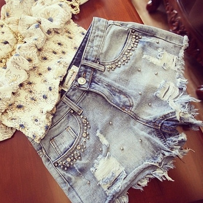 Modern women`s short jeans with patches and decorative stones in light color