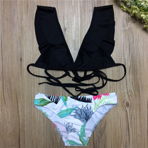 Kétrészes női fürdőruha fekete melltartóval és fehér bikini mintával
