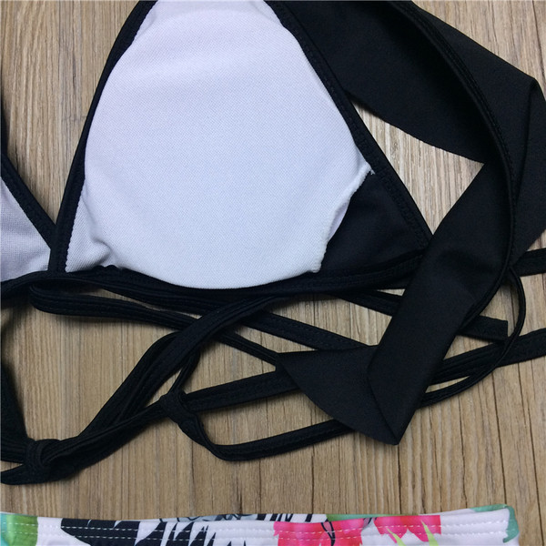 Kétrészes női fürdőruha fekete melltartóval és fehér bikini mintával