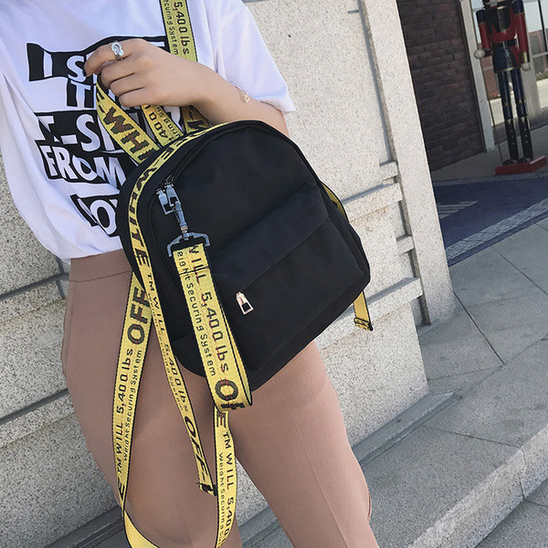 Un rucsac mic de damă cu o inscripție pe bretele