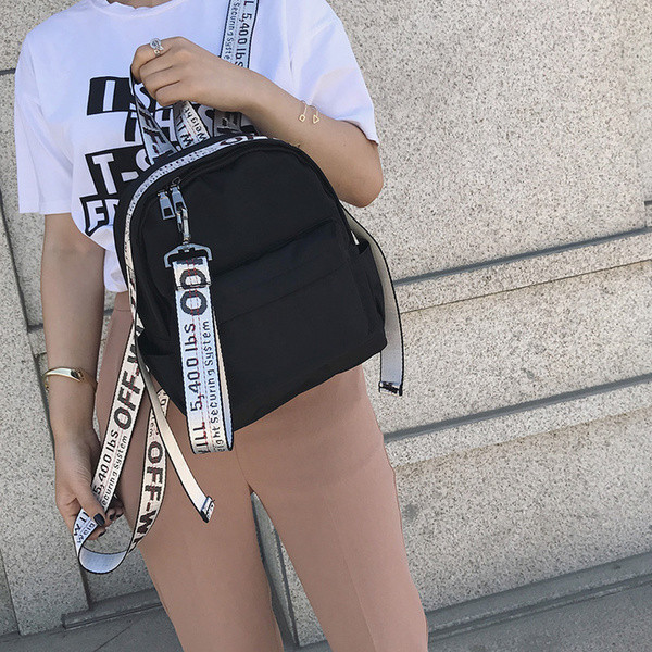 Un rucsac mic de damă cu o inscripție pe bretele