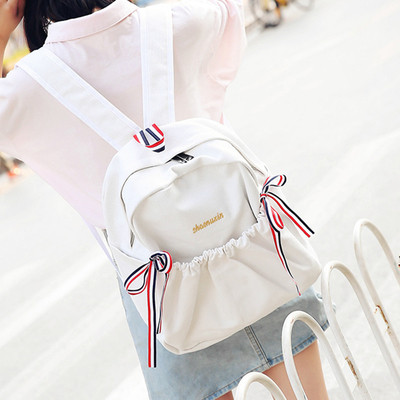 Női mindennapi hátizsák érdekes első zsebbel és szalagdísszel