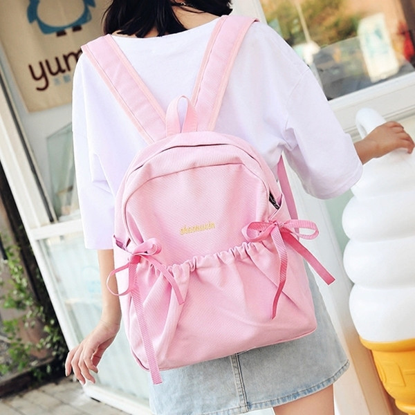 Női mindennapi hátizsák érdekes első zsebbel és szalagdísszel