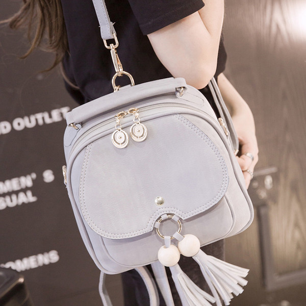 Elegáns női hátizsák két színben fém elemekkel és bojttal