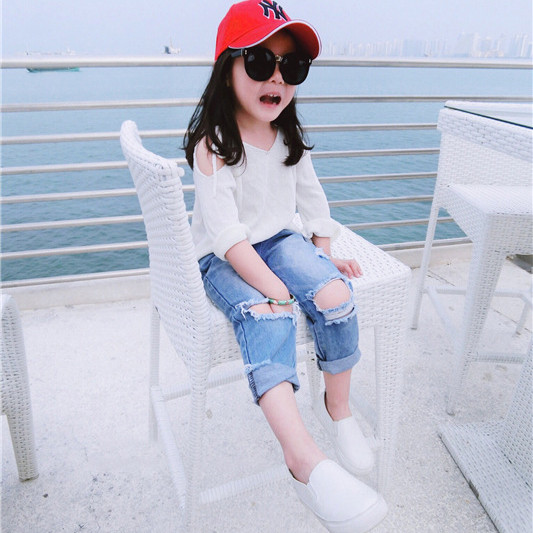 Sport gyerekfarmer lányoknak, hanyagul szakadt foltokkal, világos színben