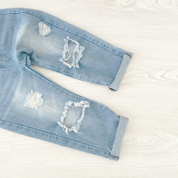 Sport gyerekfarmer lányoknak, hanyagul szakadt foltokkal, világos színben