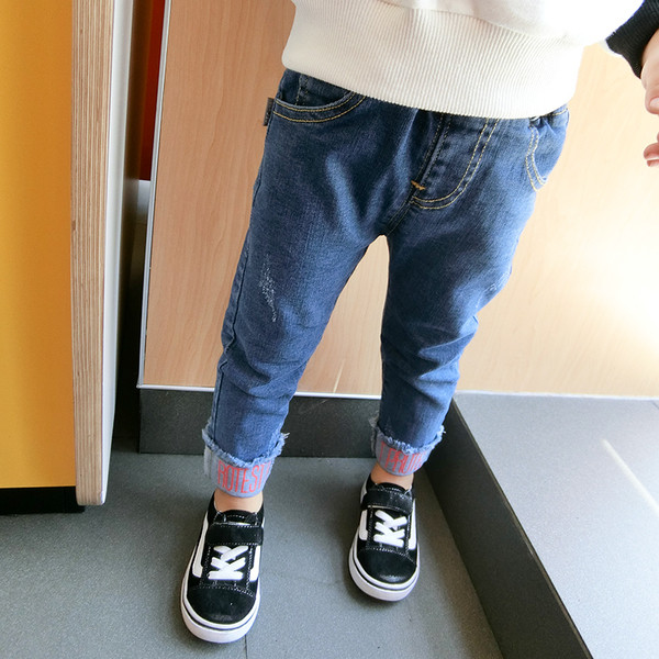 Blugi simpli pentru copii pentru fete cu un tiv interesant cu o inscripție în două culori