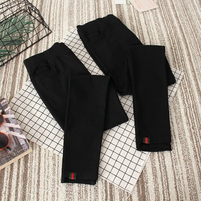 Rugalmas női leggings fekete színben, dekoratív zsebekkel és apró mintával
