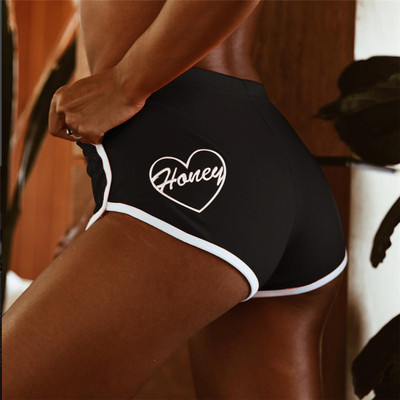 Sports and casual women`s shorts with an inscription in black and orange