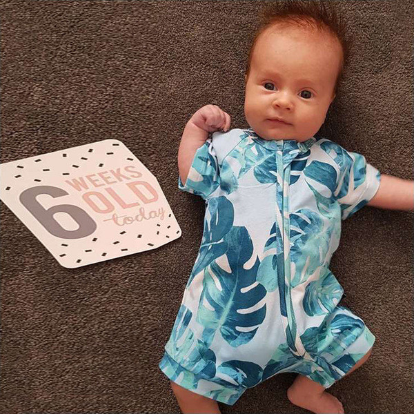 Bebelușul sportează întreaga echipă cu mâneci scurte cu motiv floral