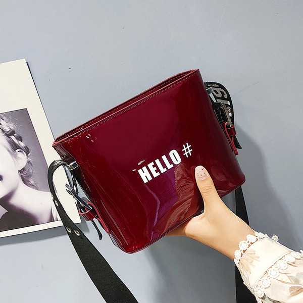 Női lakktáska széles pánttal, különböző színekben, felirattal