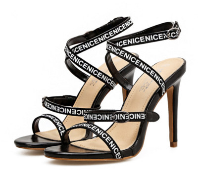 Női magas sarkú szandál vékony pánttal, fehér és fekete felirattal