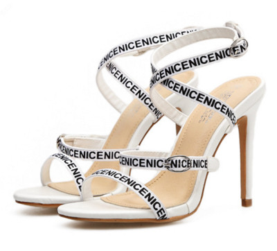 Női magas sarkú szandál vékony pánttal, fehér és fekete felirattal