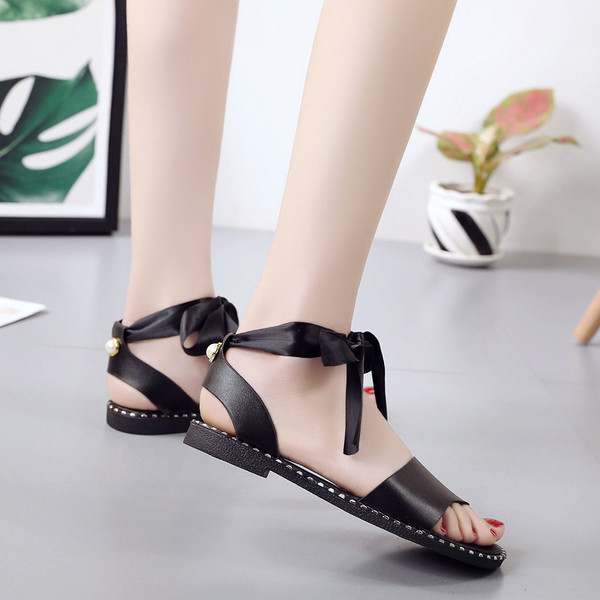 Női alkalmi szandál szalaggal a bokája körül