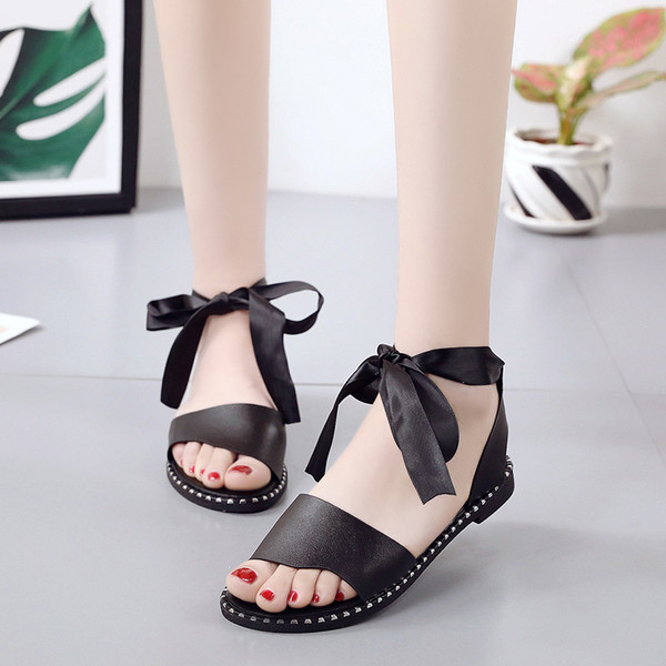 Női alkalmi szandál szalaggal a bokája körül