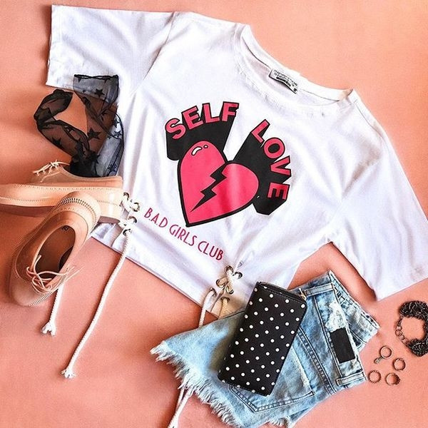 Rövid, fehér színű női póló rátéttel, megkötővel és 3/4-es ujjakkal