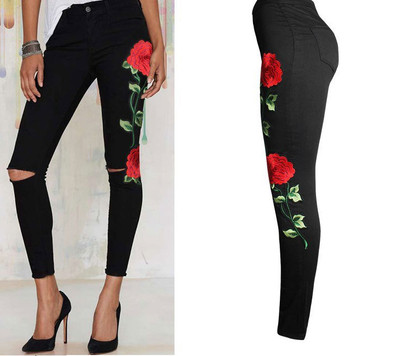 Women`s jeans with torn motifs and colorful embroidery