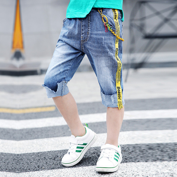 Blugi moderni pentru copii cu elemente metalice și dungi laterale colorate cu o inscripție