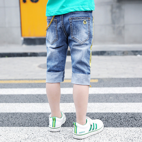 Blugi moderni pentru copii cu elemente metalice și dungi laterale colorate cu o inscripție