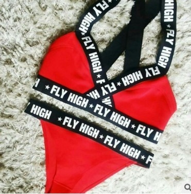 Modern női fürdőruha széles pántokkal, piros és fekete felirattal