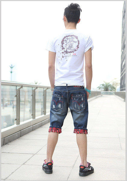 Sötét színű, szakadt motívumokkal ellátott rövid férfi farmer