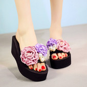 Γυναικείες παντόφλες με μαύρο χρώμα σε μια πλατφόρμα με floral διακόσμηση