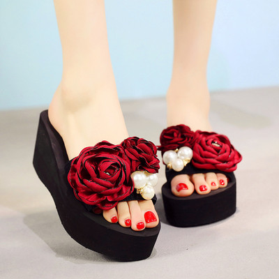 Γυναικείες παντόφλες με μαύρο χρώμα σε μια πλατφόρμα με floral διακόσμηση