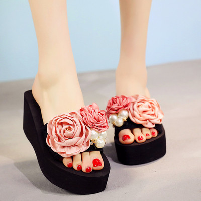 Γυναικείες παντόφλες με μαύρο χρώμα σε μια πλατφόρμα με floral διακόσμηση