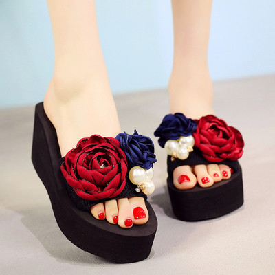 Γυναικείες παντόφλες με μαύρο χρώμα σε μια πλατφόρμα με floral διακόσμηση