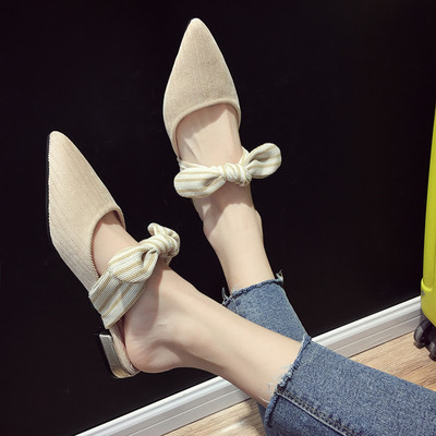 Μοντέρνες γυναικείες παντόφλες σε μια επίπεδη σόλα σε δύο χρώματα