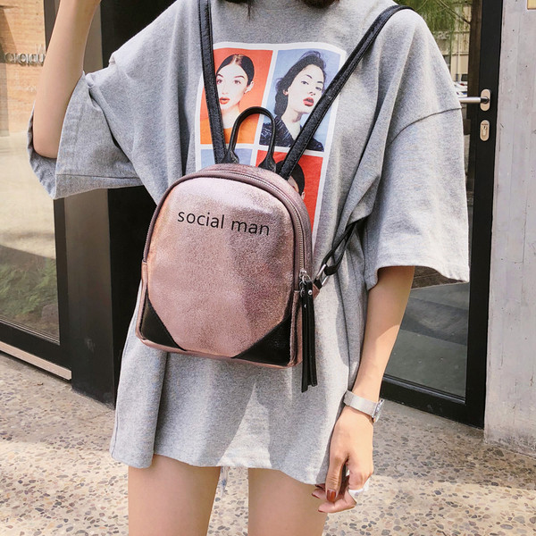 Un rucsac mic de damă strălucitor cu o inscripție în mai multe culori