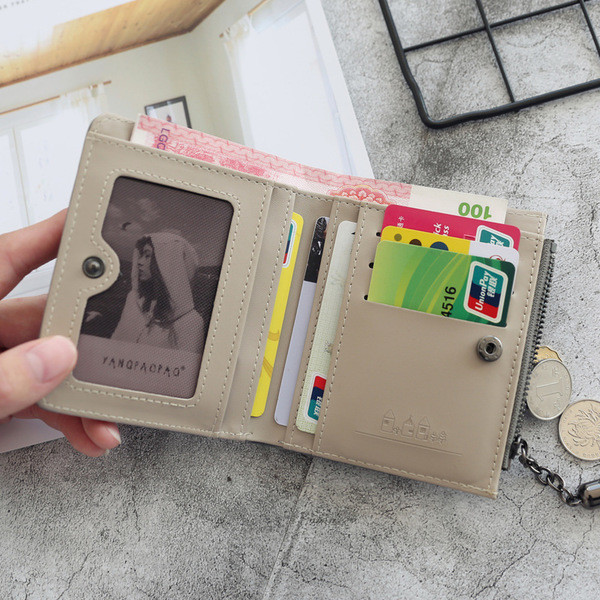 Un portofel mic de dama cu motive florale si un ciucuri in mai multe culori