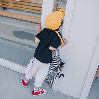 Παιδική βαμβακερή μπλούζα με εφαρμογές και σχισμένα σχέδια σε λευκό και μαύρο χρώμα