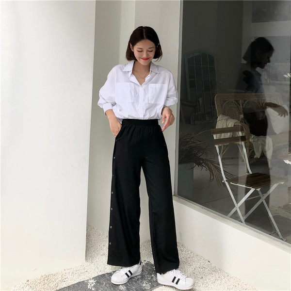 Модерен дамски панталон в черен цвят с копчета и карирана подплата