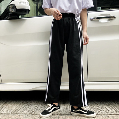 Спортен дамски панталон в черен цвят с бели кантове и цепки